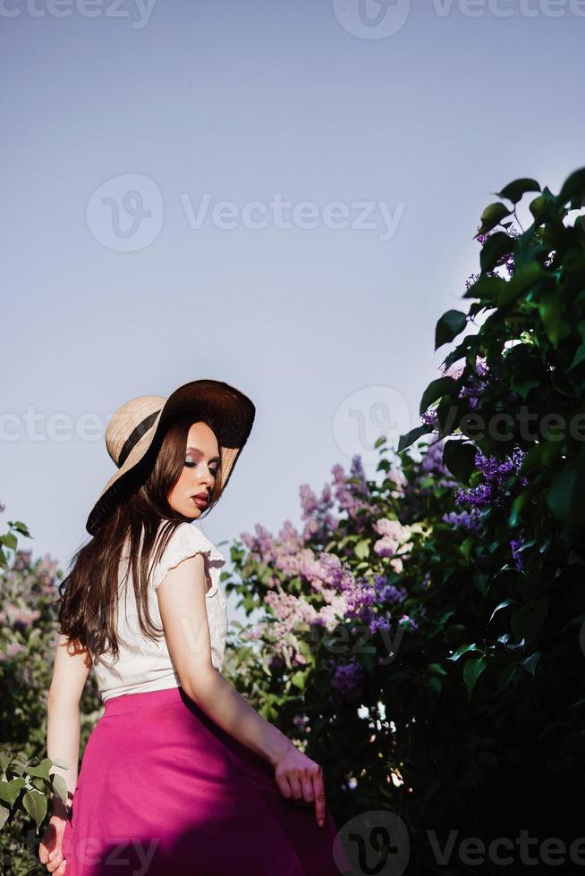 un de moda niña con oscuro cabello, un primavera retrato en lila tonos en verano. brillante profesional constituir. foto