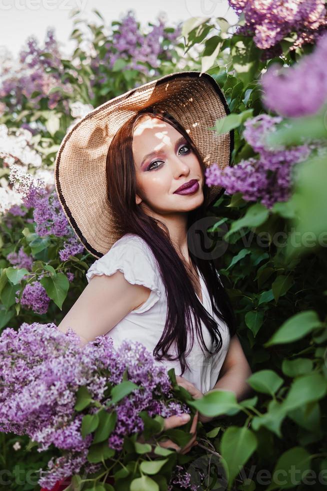 A fashionable girl with dark hair, a spring portrait in lilac tones in summer. Bright professional makeup. photo