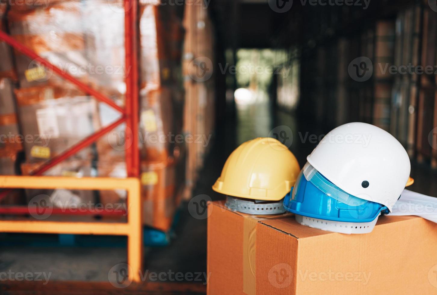 white, yellow and blue hard safety helmet hat for safety protection of workman as engineer or worker in warehouse industry photo