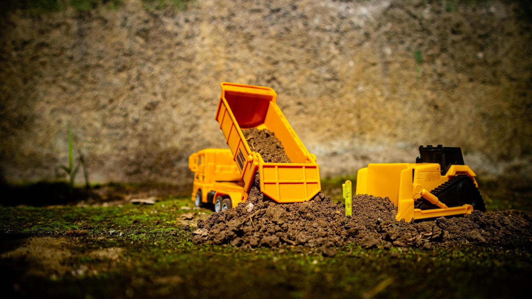 South Minahasa, Indonesia  January 2023, a yellow dump truck toy transporting sand photo