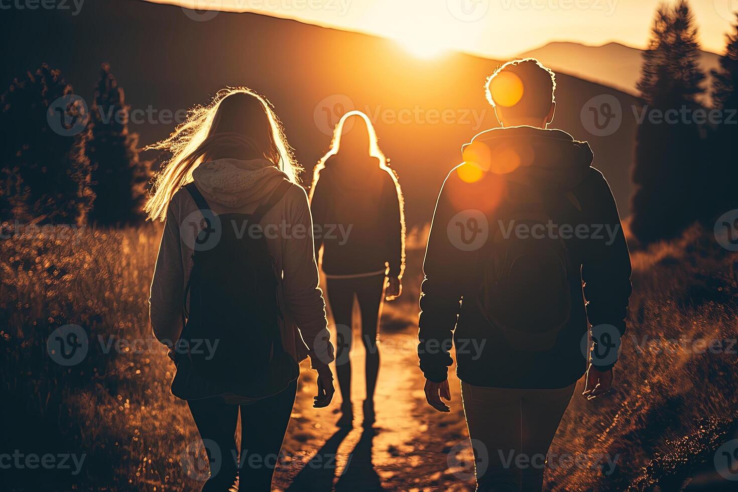 Group of friends hiking in the mountains at sunset. . photo