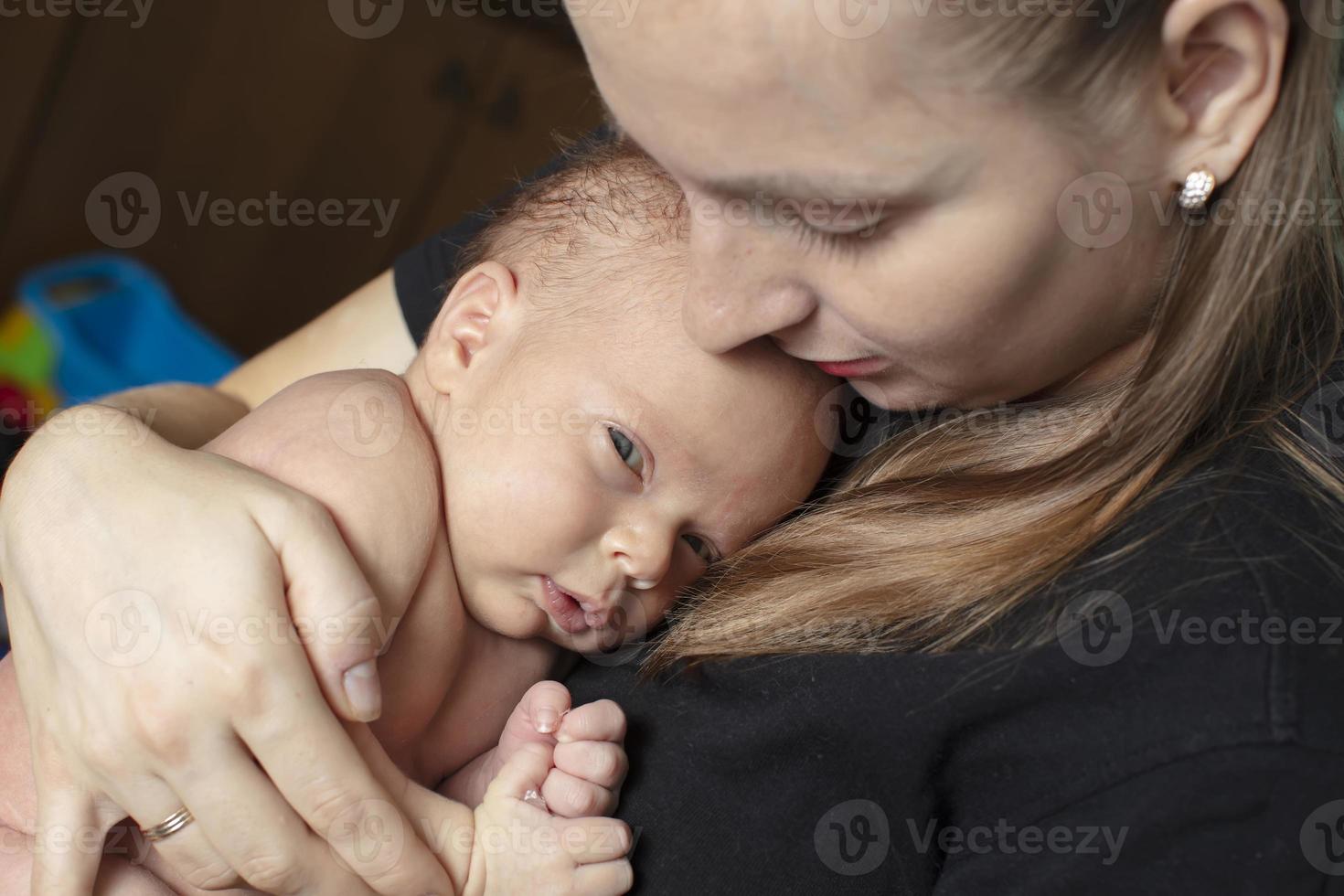 The newborn girl clung to her mother. Young woman with a baby. photo