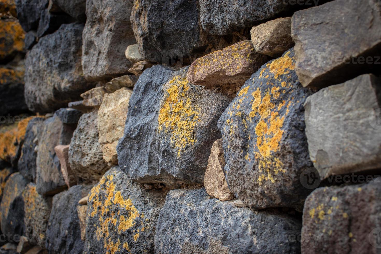 Close up yellow lichen cover the rough stone wall concept photo. Show with macro view. Rocks full of the moss texture in nature for wallpaper. photo