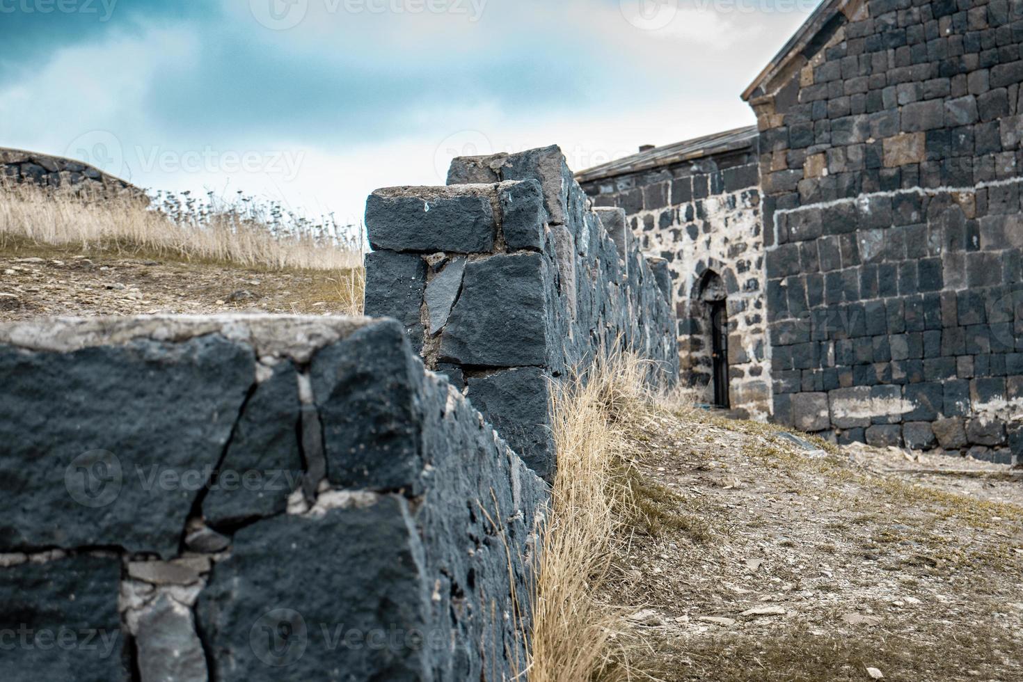 Close up fence stone wall surface with cement on yard concept photo. Rocks full of texture. Part of ancient building view for wallpaper. photo