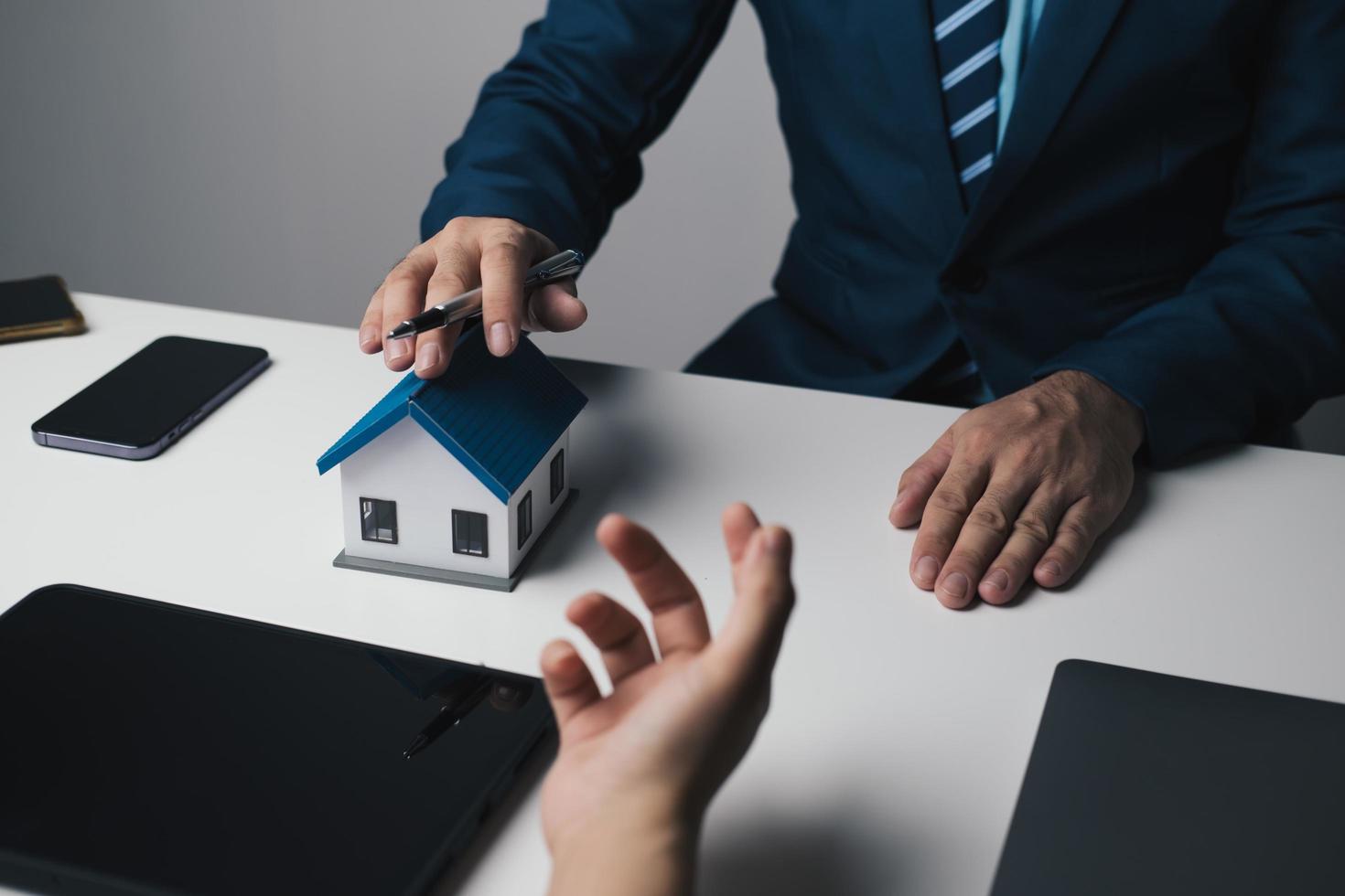 Close up view of young businessman or real estate agent explaining the term and agreement to his client. photo