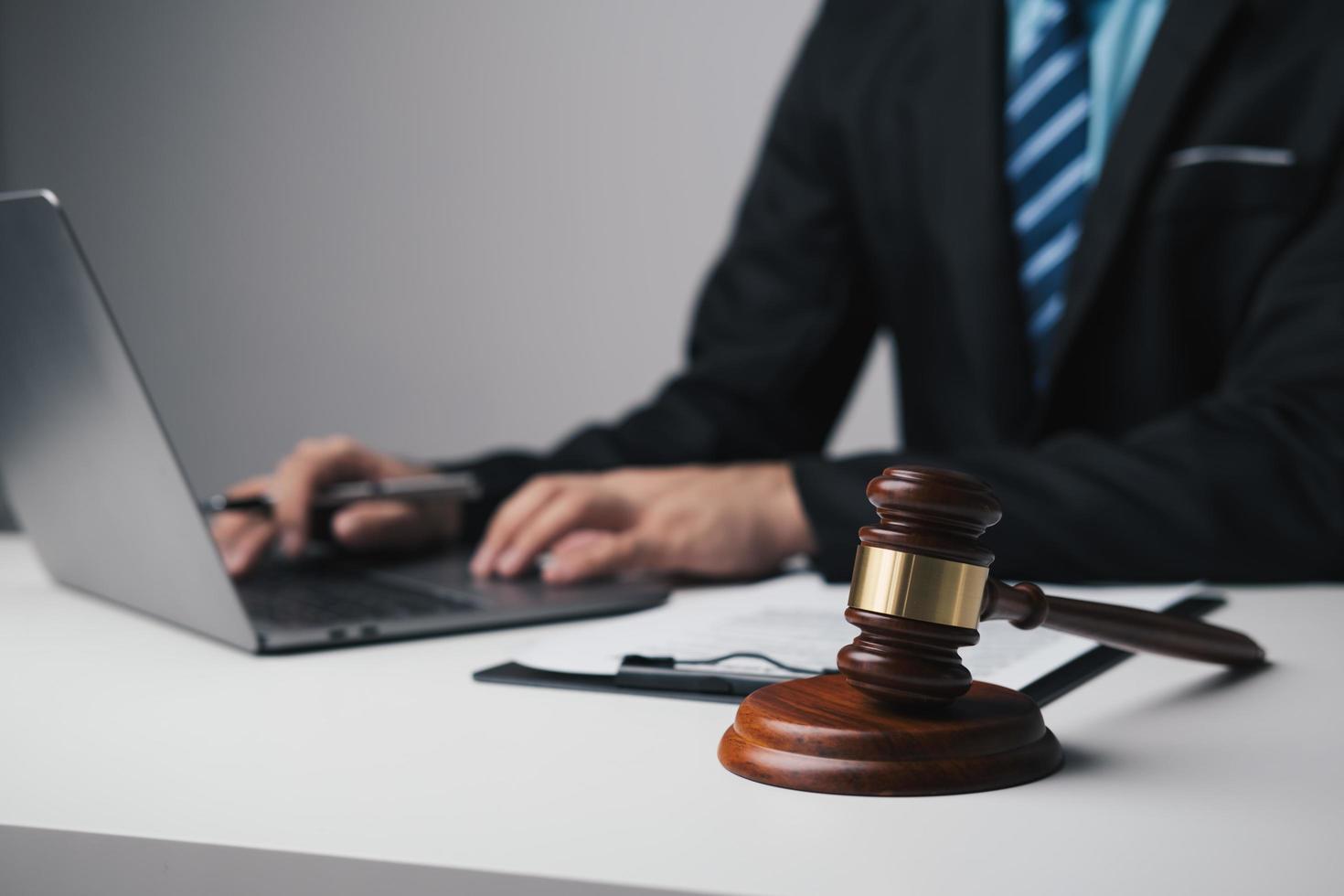 Close up view of lawyer working on his laptop computer, working for his client in the office room. photo