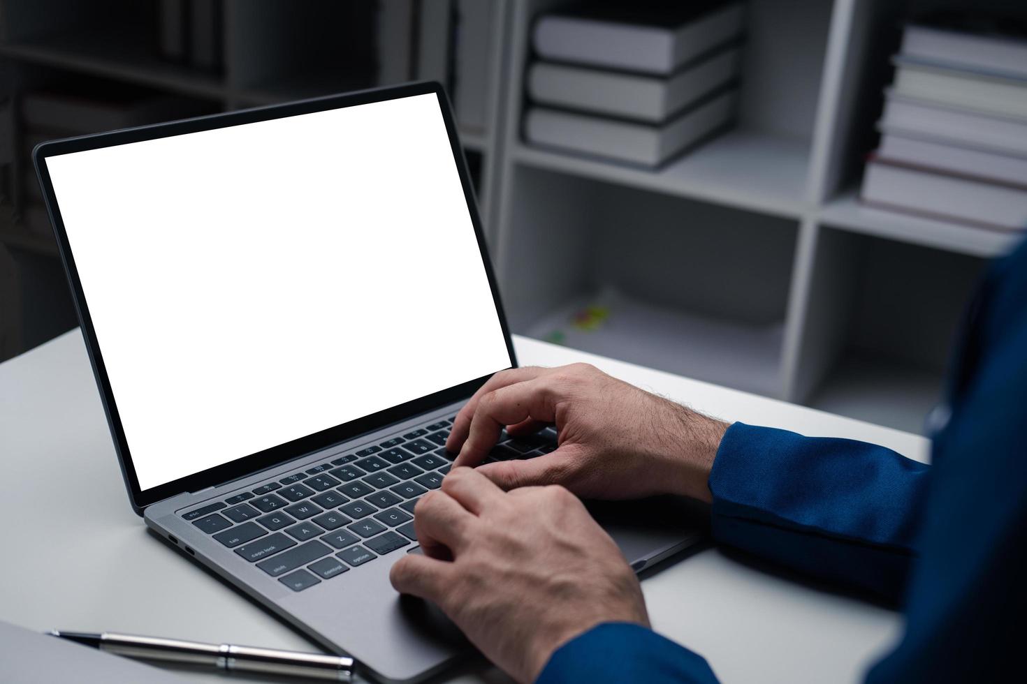 Close up view of businessman using laptop computer at office desk in the office room. photo