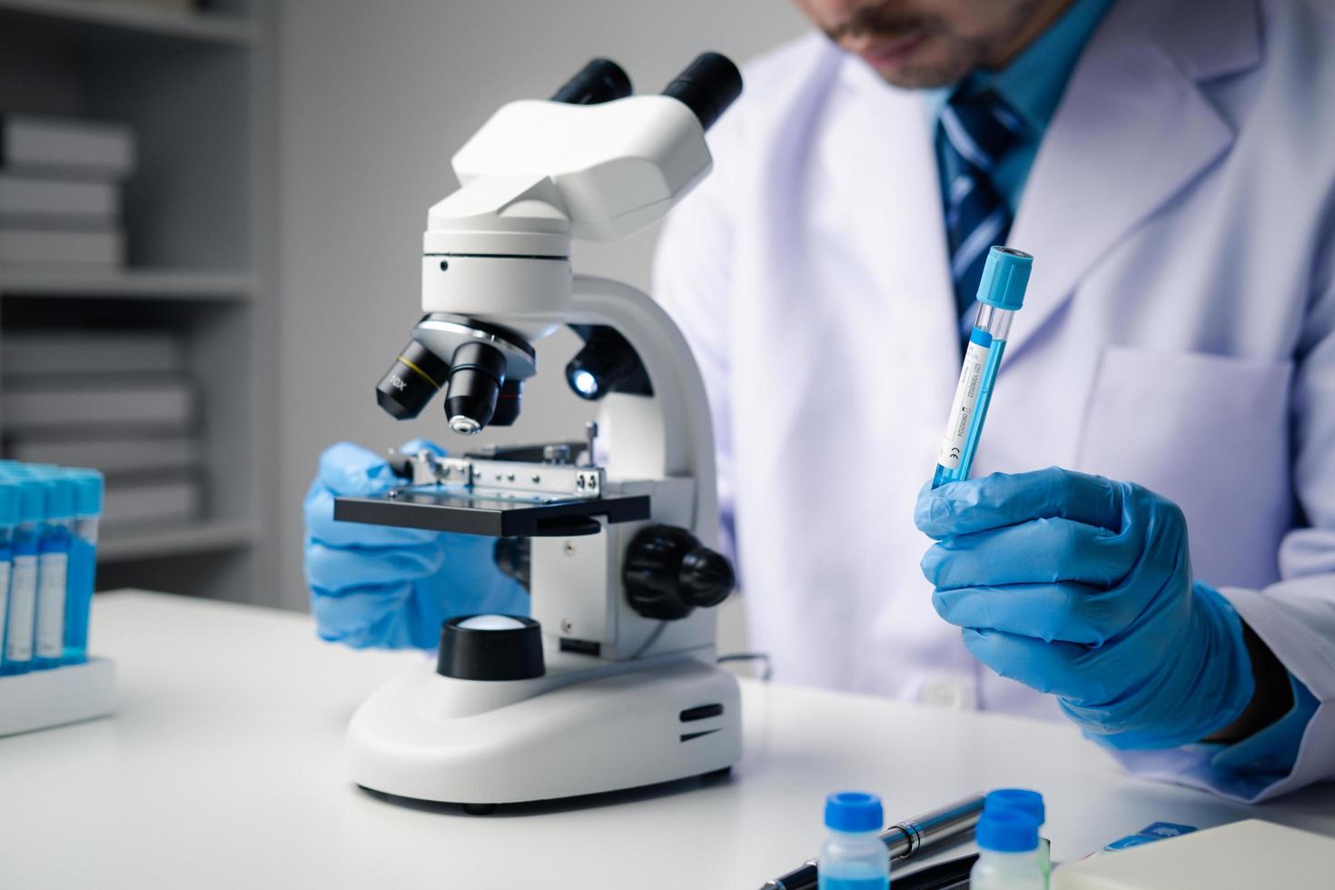 Professional scientist using microscope while working on medical research in science laboratory. photo