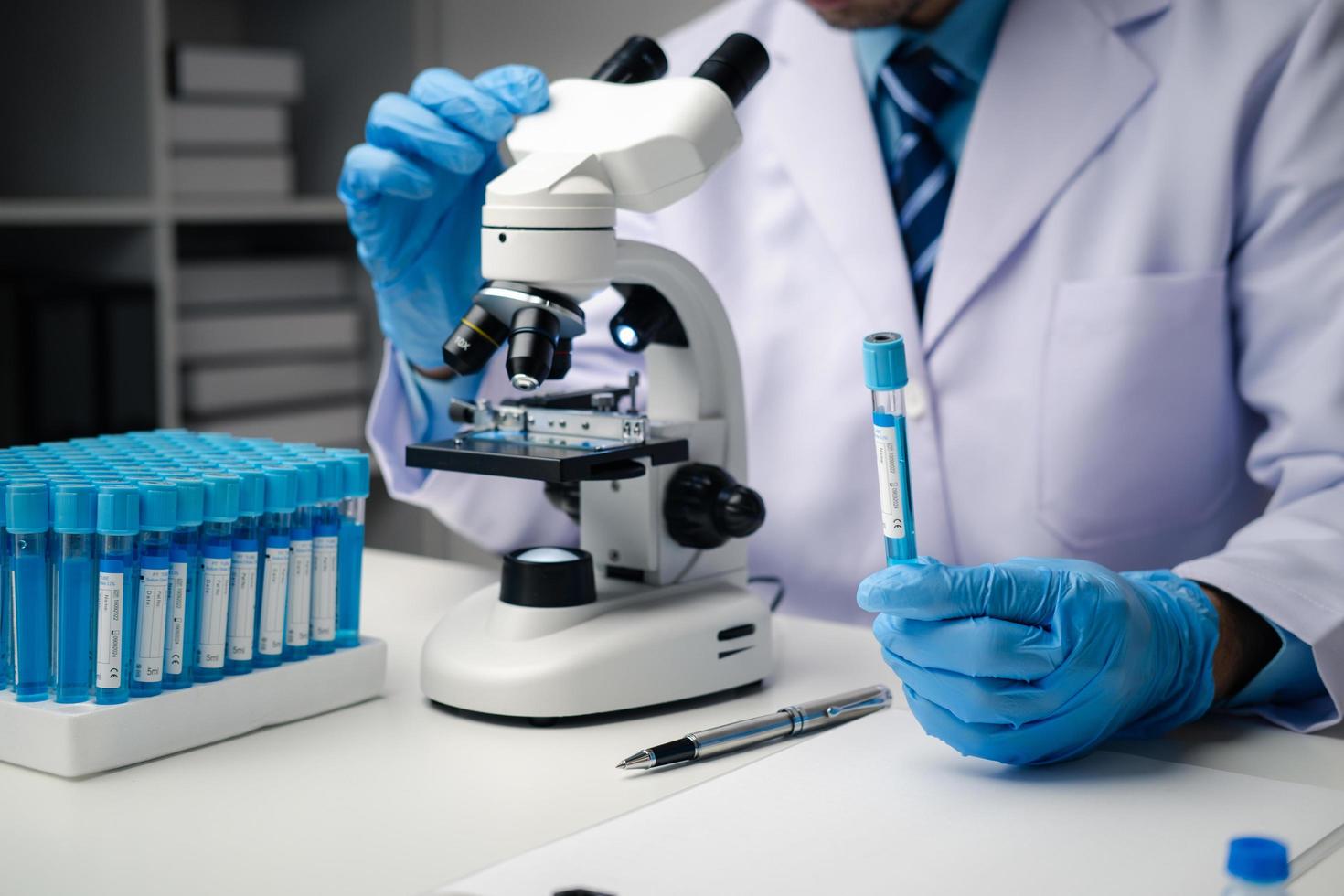 Professional scientist using microscope while working on medical research in science laboratory. photo