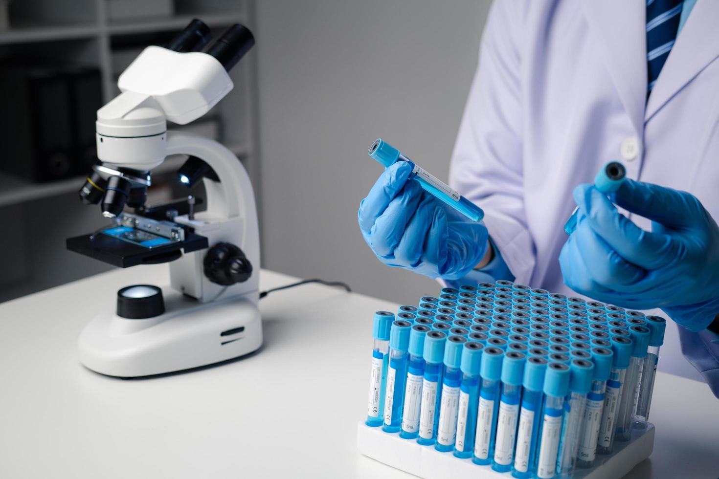 Close up view of scientist analyzing a liquid in the test tubes in laboratory. photo