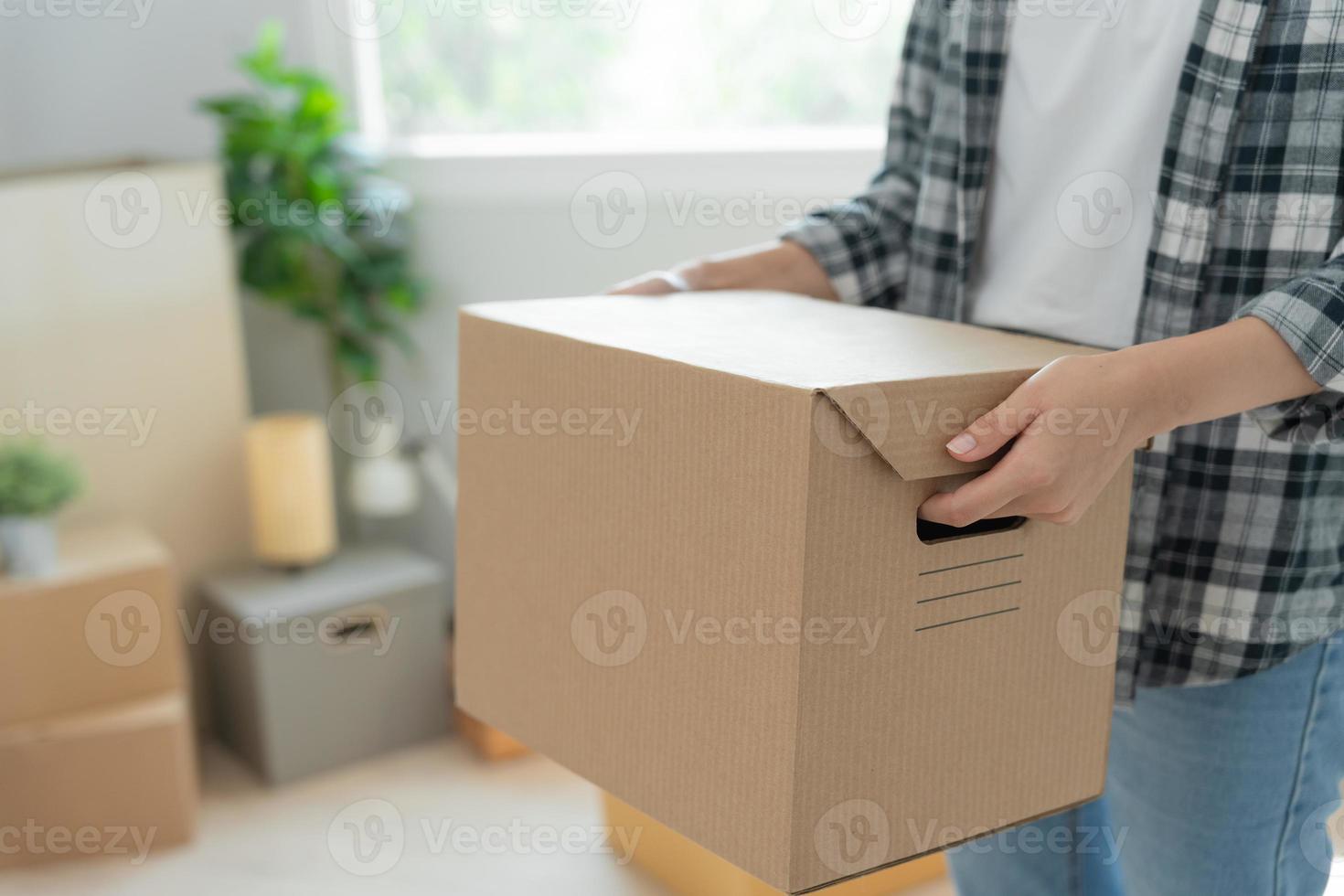 Moving house, relocation. Woman hand holding carton box on new apartment, inside the room was a cardboard box containing personal belongings and furniture. move in the house or condominium photo