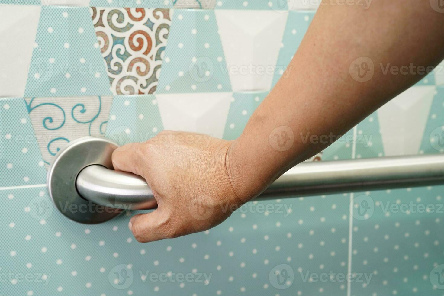 Asian woman patient use toilet support rail in bathroom, handrail safety grab bar, security in nursing hospital. photo