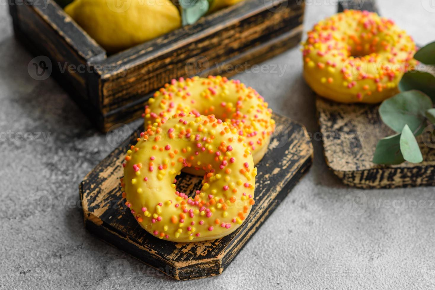 Delicious fresh donuts in yellow glaze with lemon flavor filling photo