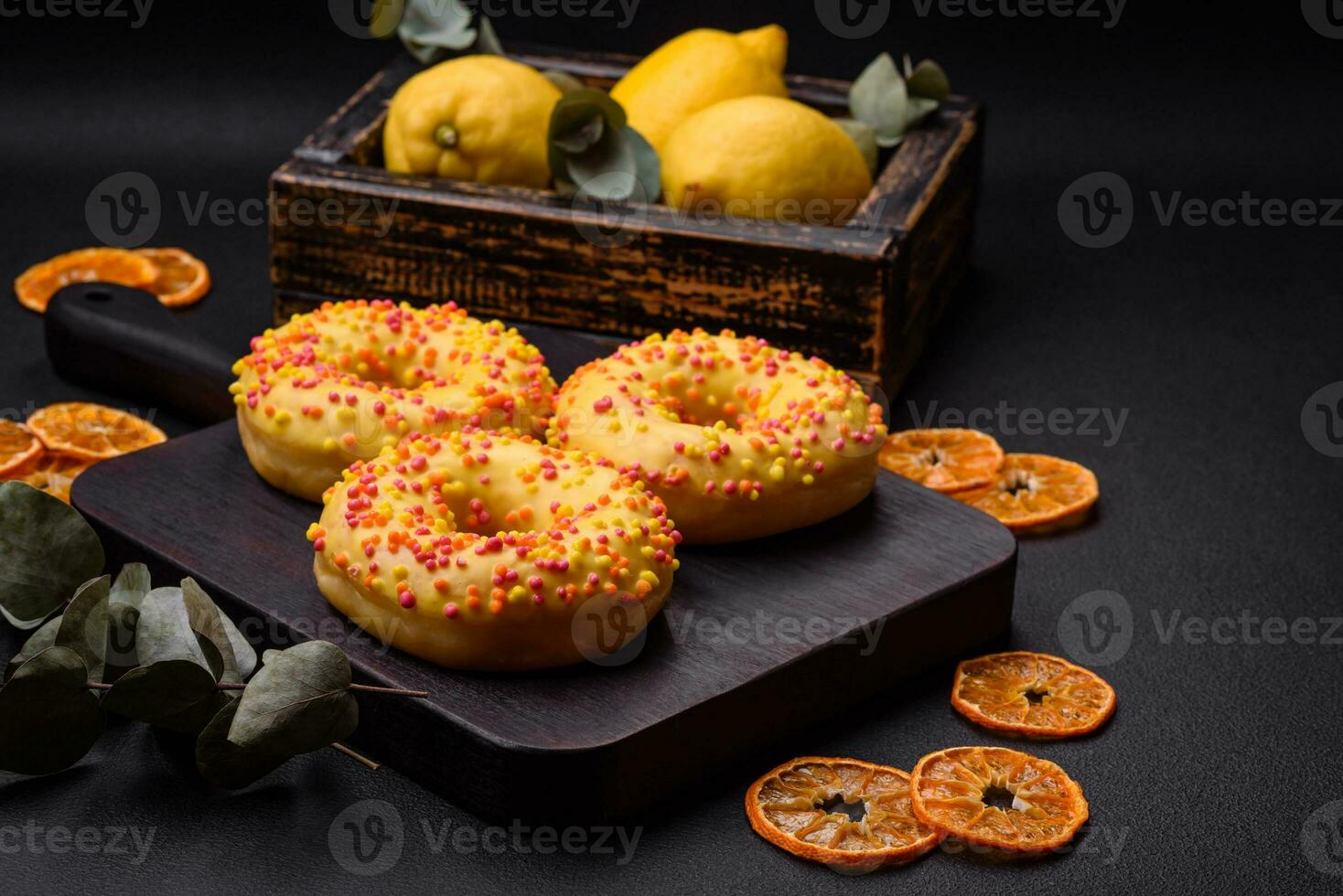 Delicious fresh donuts in yellow glaze with lemon flavor filling photo