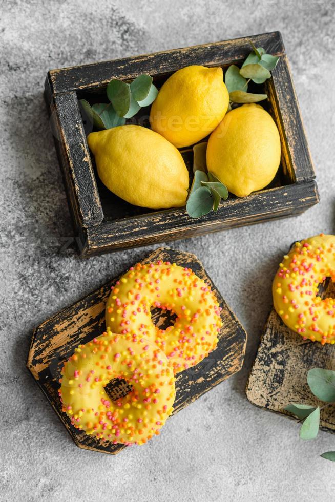 Delicious fresh donuts in yellow glaze with lemon flavor filling photo