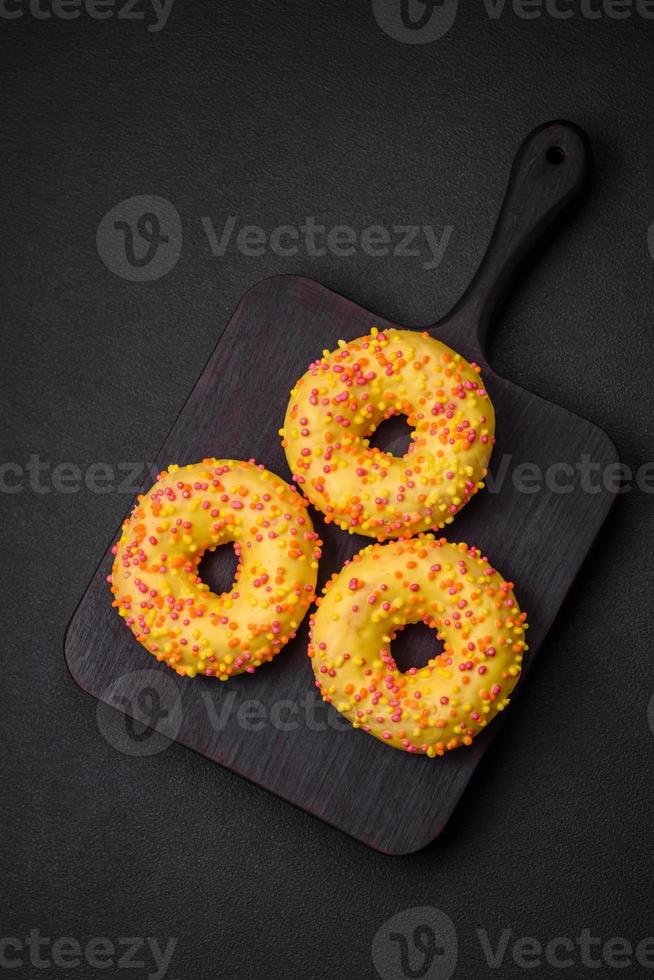 Delicious fresh donuts in yellow glaze with lemon flavor filling photo