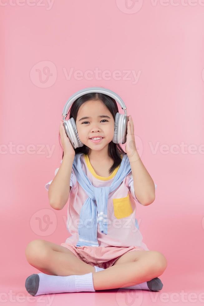 Asia little girl cute put on headphones have video call distant class with teacher using laptop, study online on computer, homeschooling concept photo