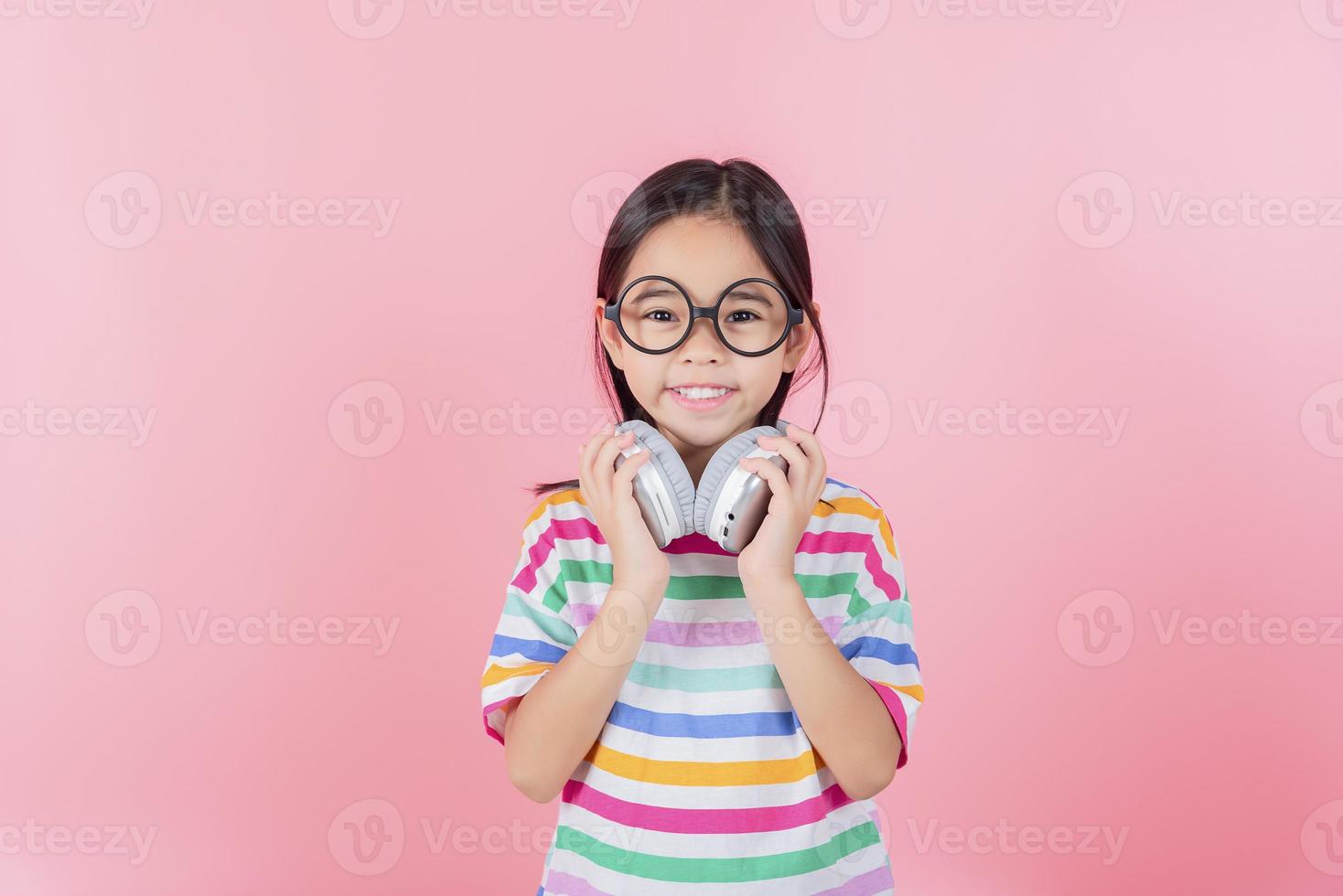 Asia little girl cute put on headphones have video call distant class with teacher using laptop, study online on computer, homeschooling concept photo