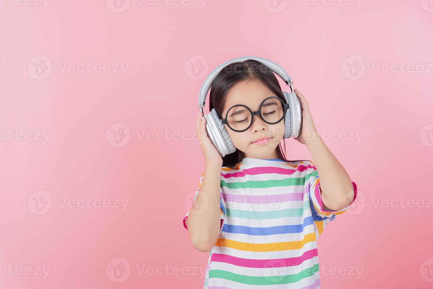 Asia little girl cute put on headphones have video call distant class with teacher using laptop, study online on computer, homeschooling concept photo