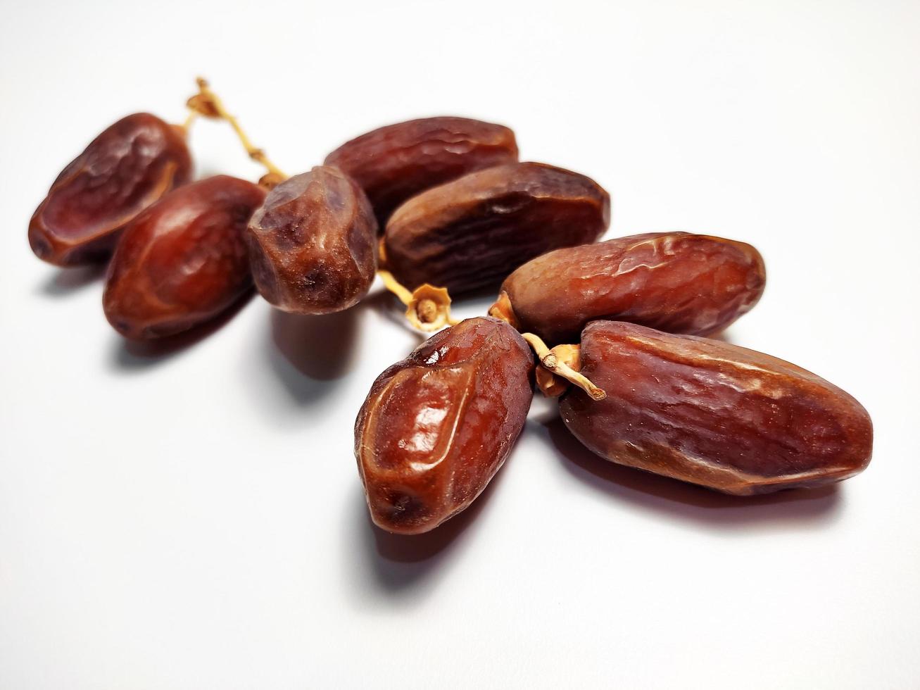 Dried dates on stalk, white background photo