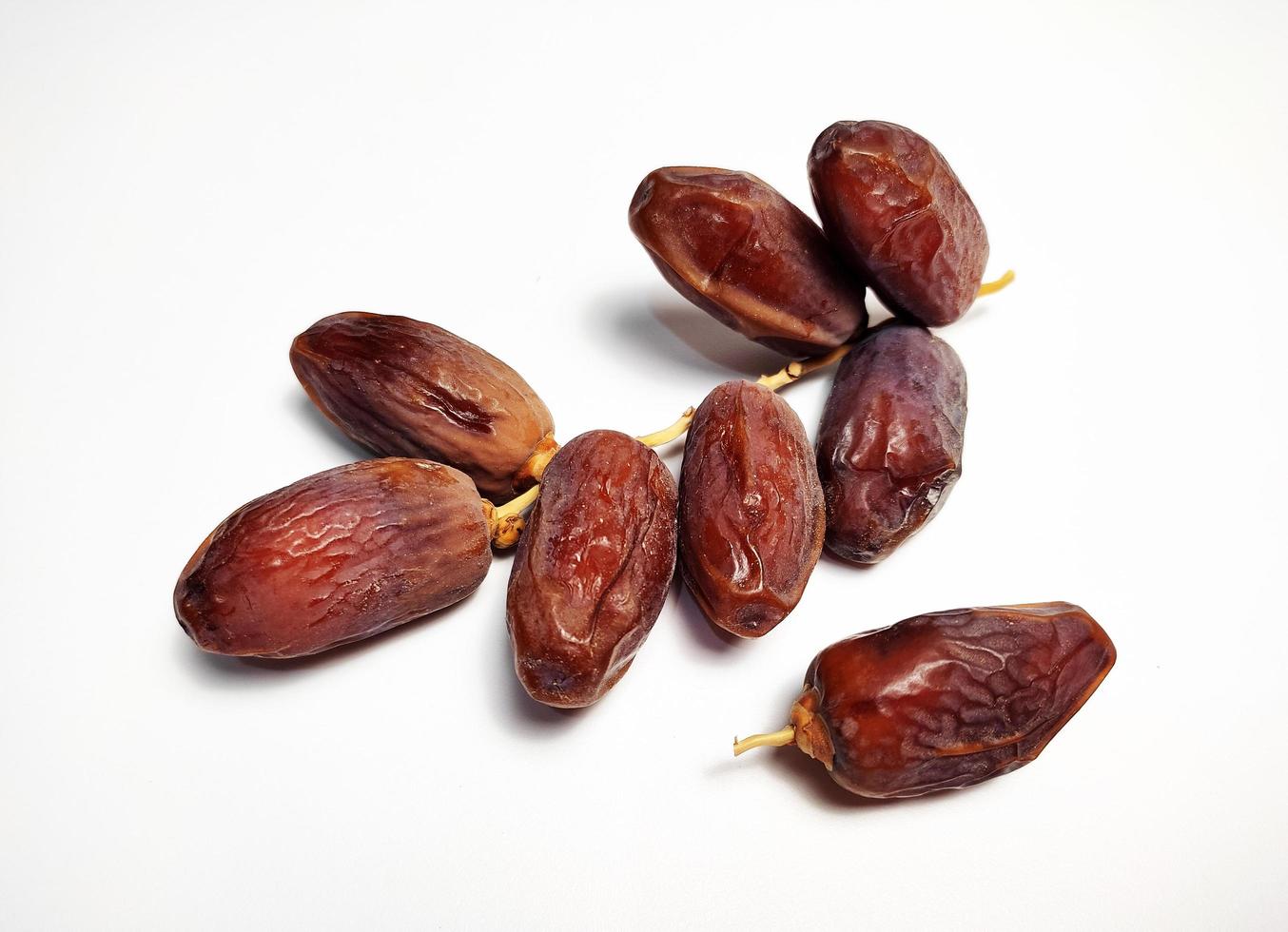 Dried dates on stalk, white background photo