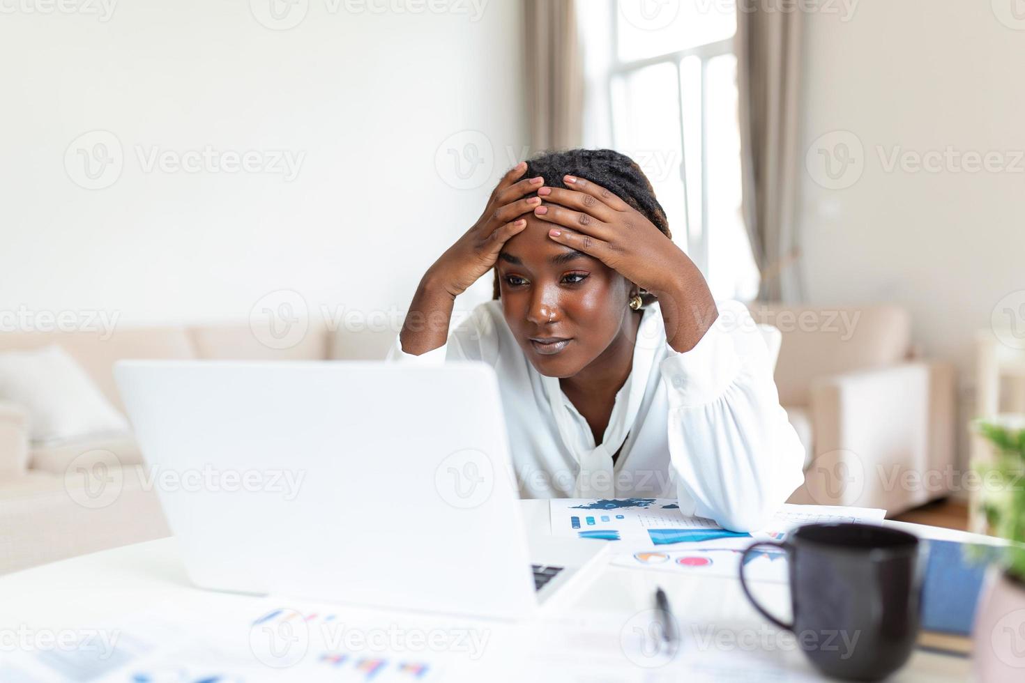 Confused businesswoman annoyed by online problem, spam email or fake internet news looking at laptop, female office worker feeling shocked about stuck computer, bewildered by scam message or virus photo