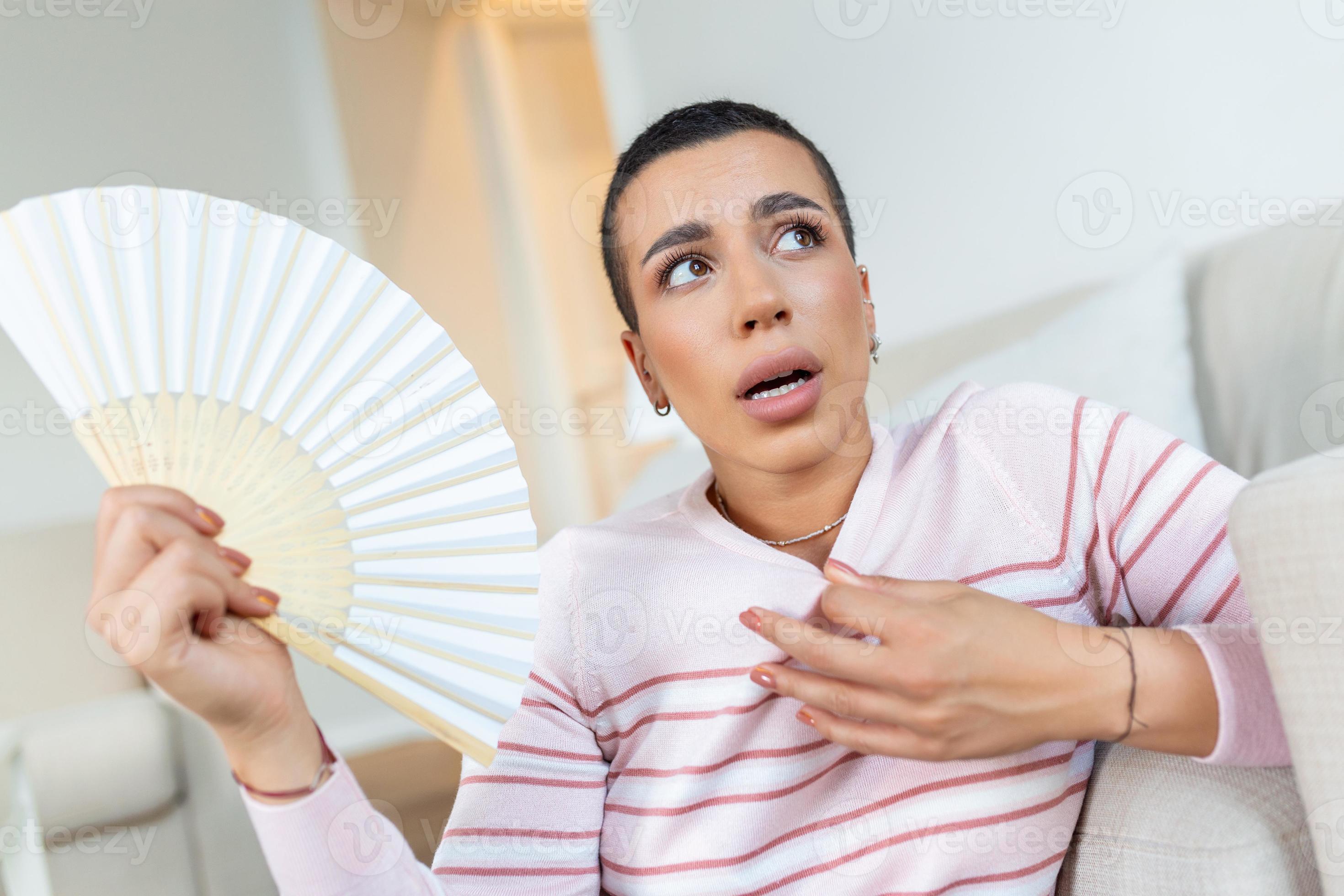 Stressed annoyed woman using waving fan suffer from overheating, summer