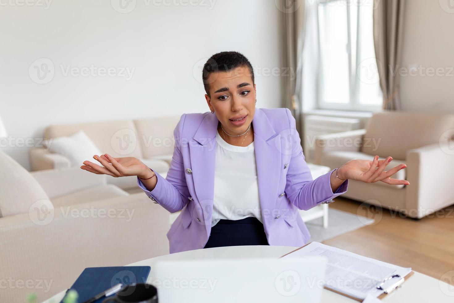 Confused businesswoman annoyed by online problem, spam email or fake internet news looking at laptop, female office worker feeling shocked about stuck computer, bewildered by scam message or virus photo