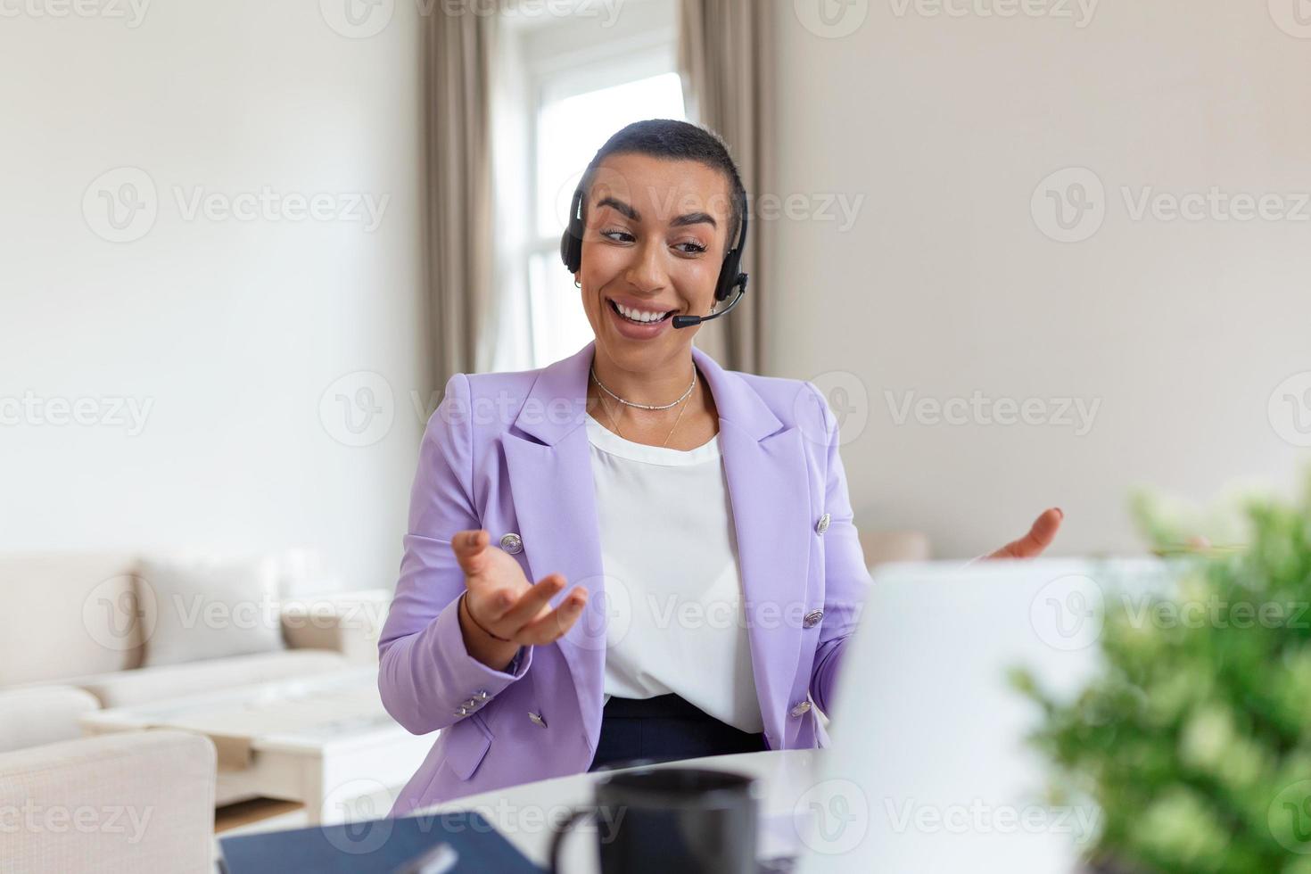 Happy woman wearing headphones and microphone looking at webcam, smiling at camera, laughing during virtual meeting or video call talk. Employee working from home. Screen view head shot photo