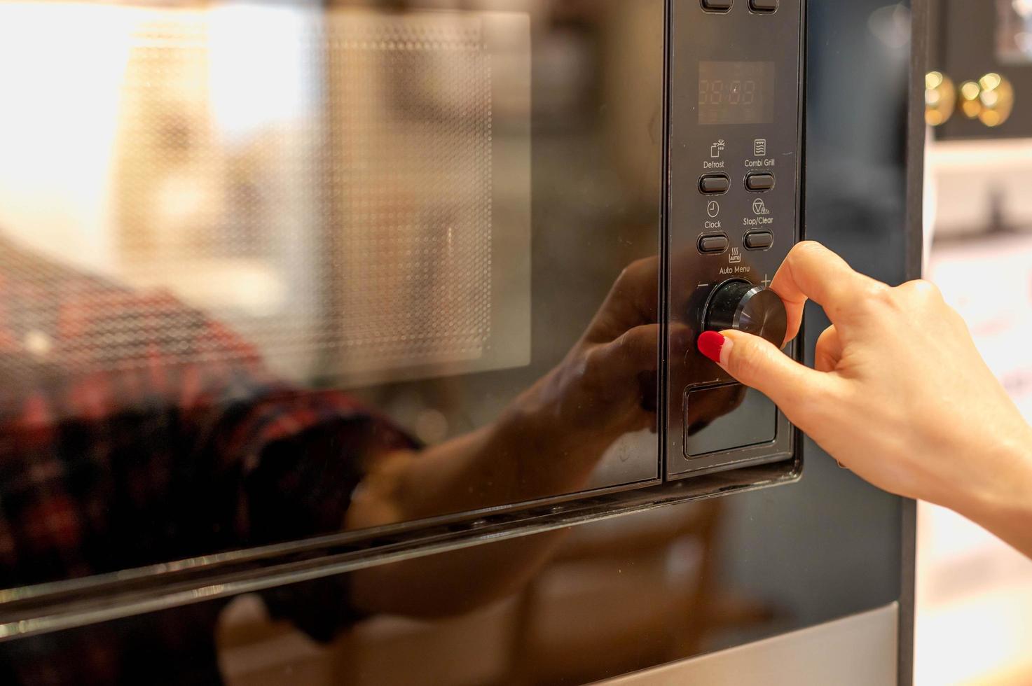 Close-up female hand Opening Or Closing modern electric oven prepare to cook in the modern kitchen. photo