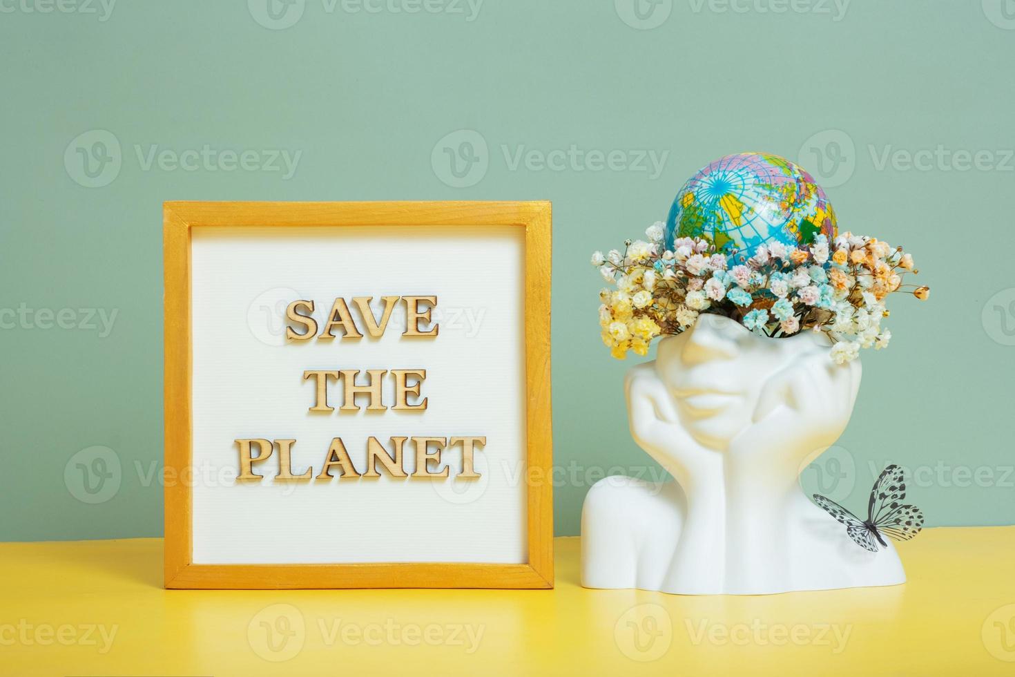 Save the planet text with world globe in head with flowers.  Environment for the future, concept of saving the planet photo