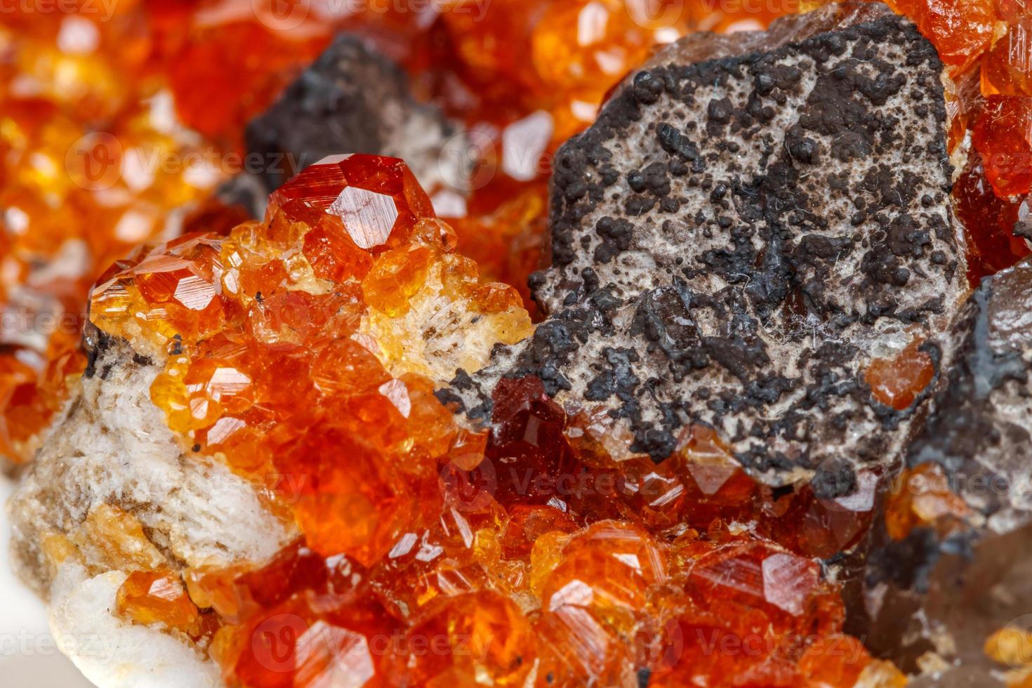 macro mineral stone Spessartine, orange, red garnet with quartz on white background photo