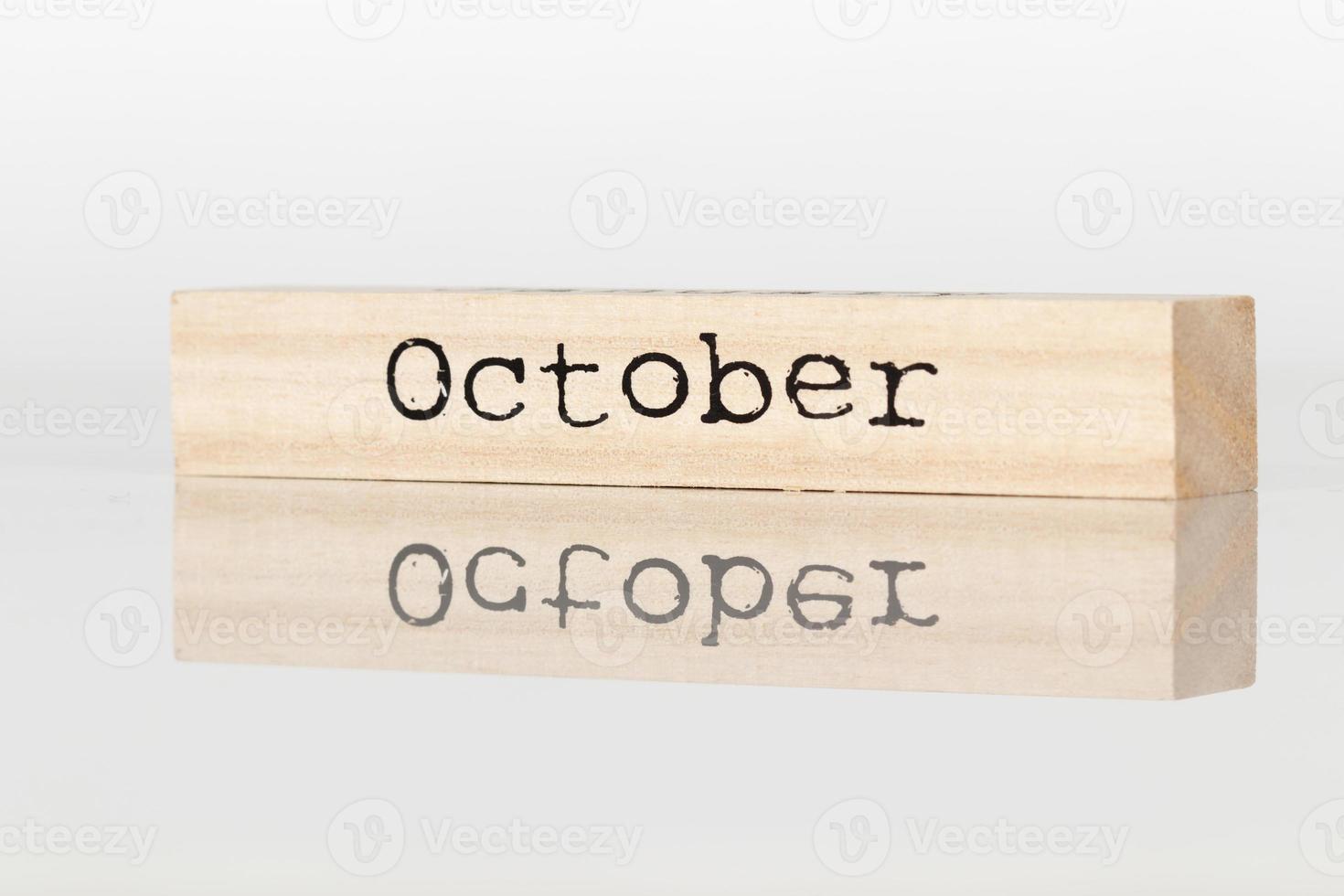 wooden cube with an inscription October on a white background photo