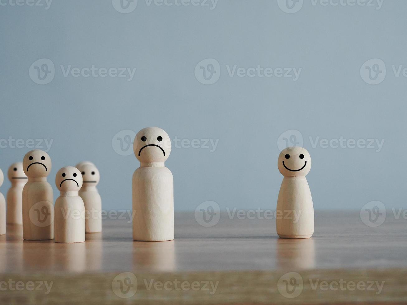 un de madera marioneta de madera cubo con un contento sonriente rostro. separando desde un sociedad lleno de ceñudo o infeliz caras foto