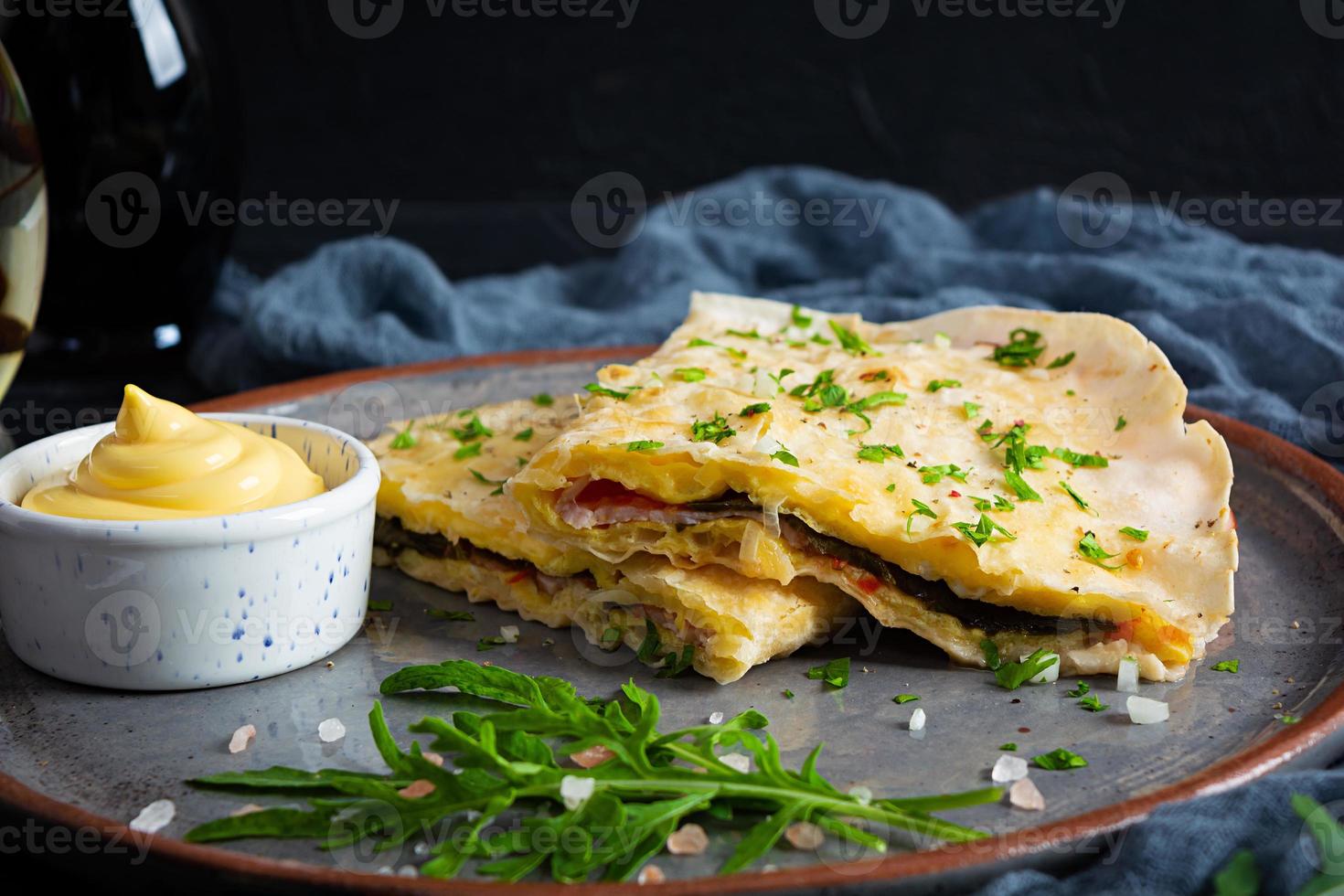 Fried pita bread with scrambled eggs, tomatoes, meat and cheese. Stuffed lavash photo