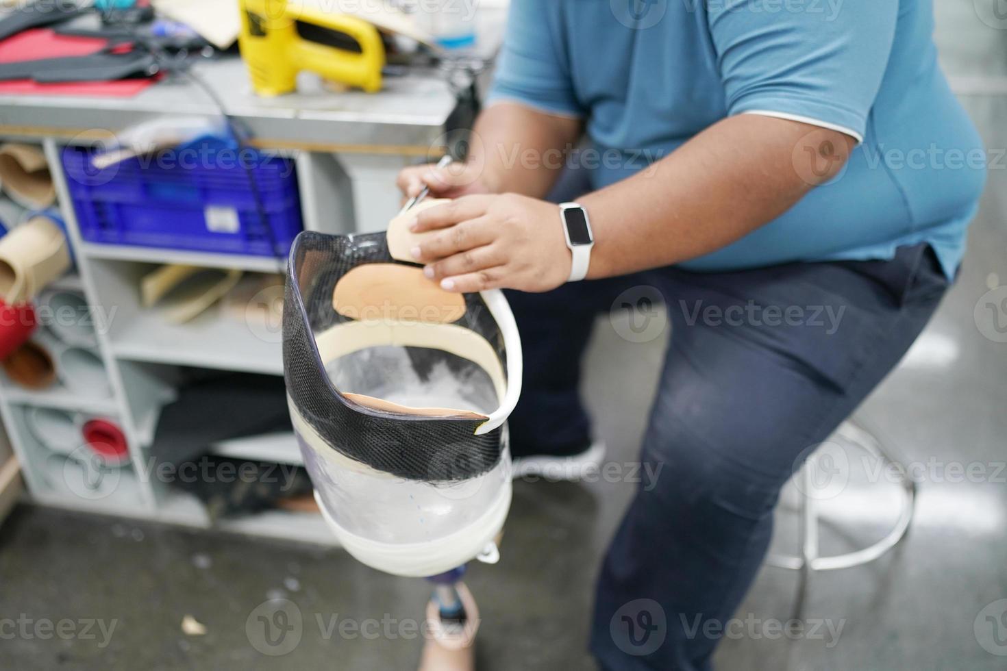 Orthopedic technician making prosthetic leg for disabilities people in workshop. photo