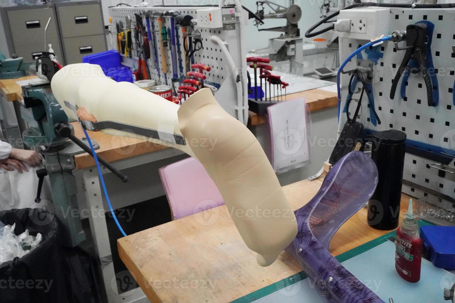 Orthopedic technician making prosthetic leg for disabilities people in workshop. photo