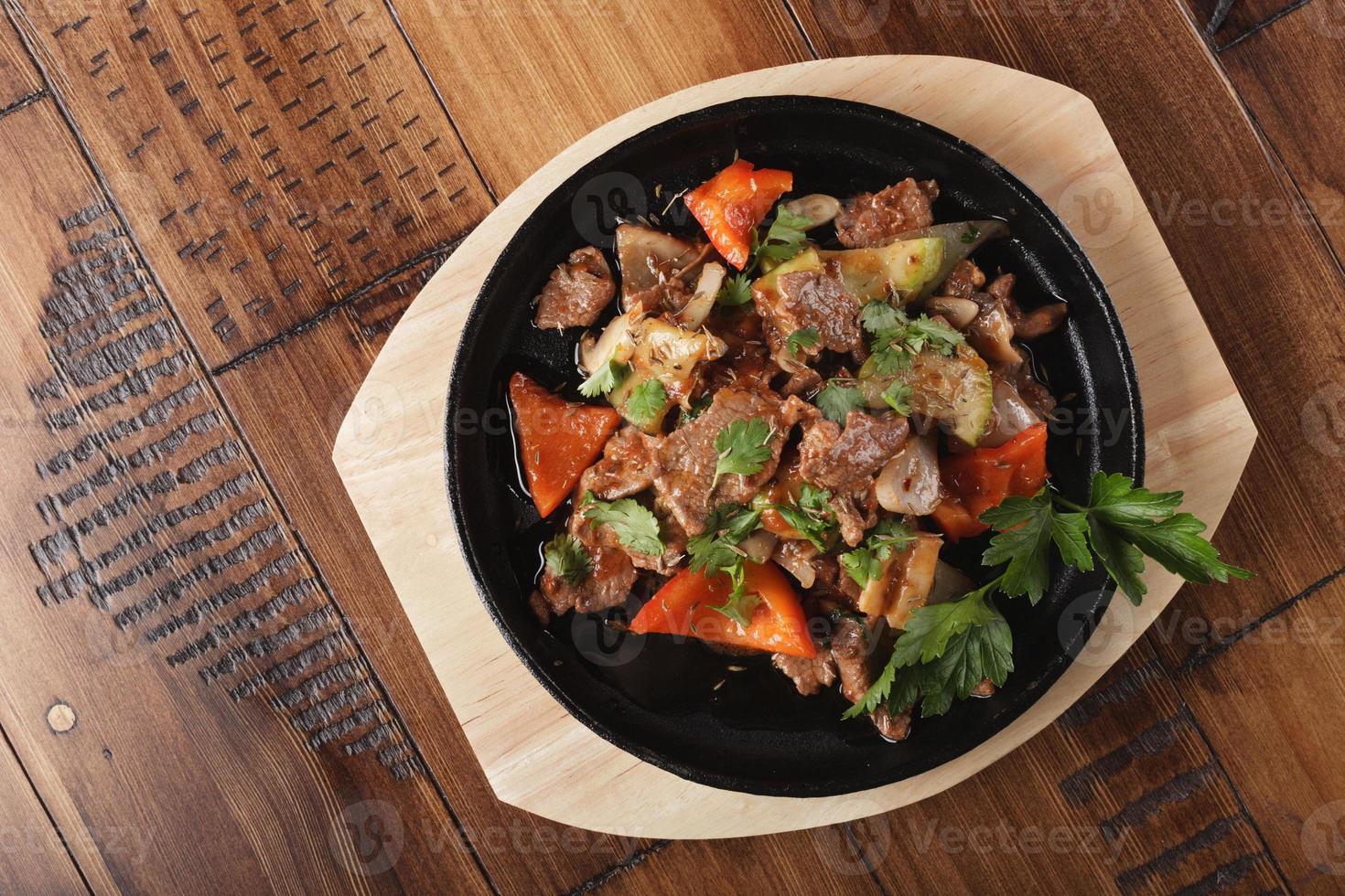 Fried lamb meat slices with vegetables photo