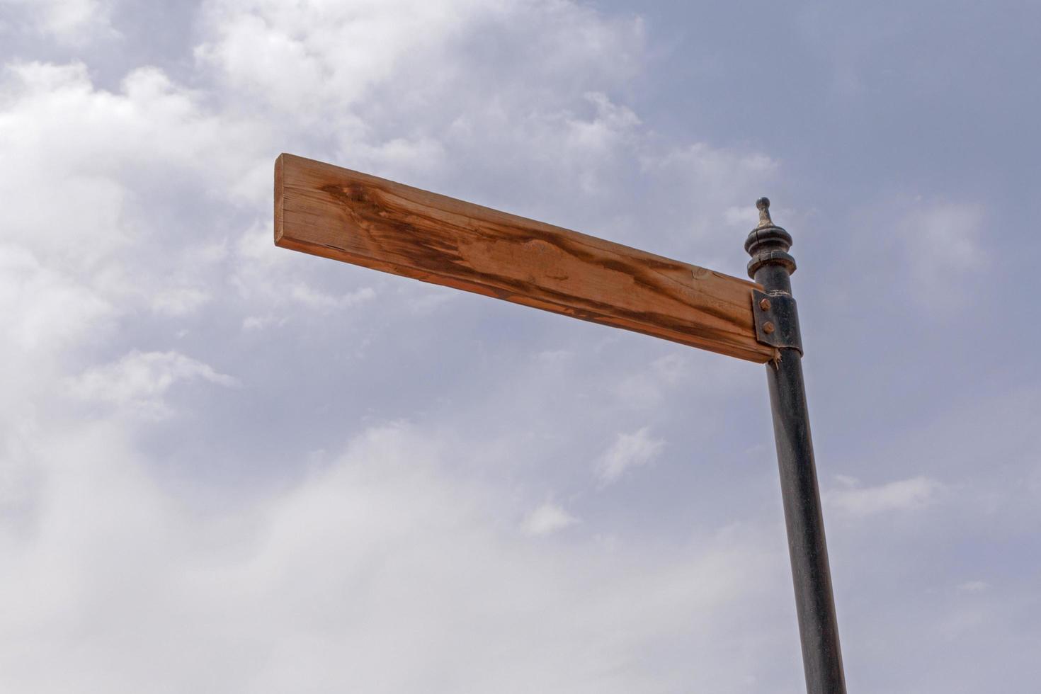 empty wooden pointer on pole against sky photo