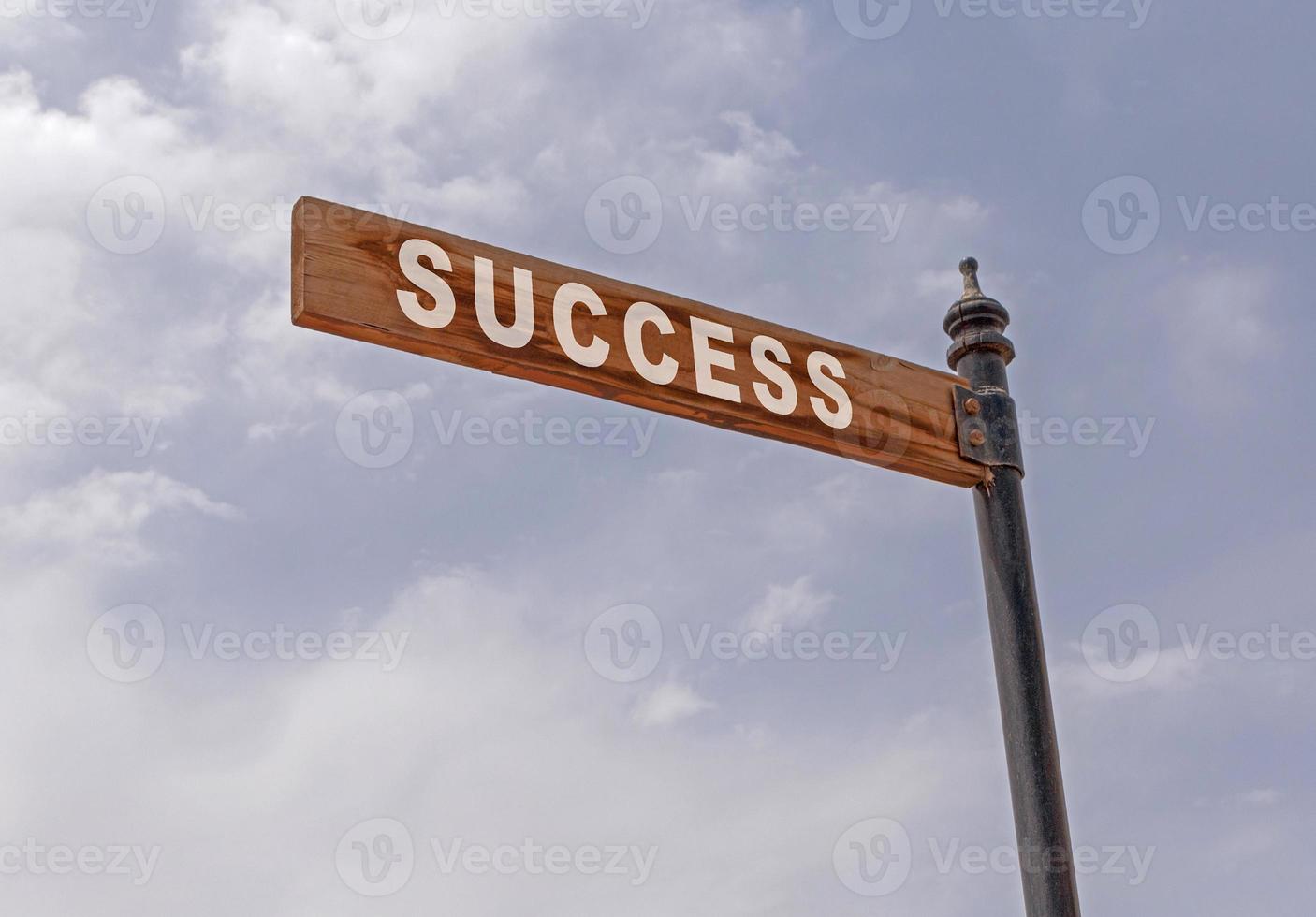 success pointer on pole against cloudy sky photo