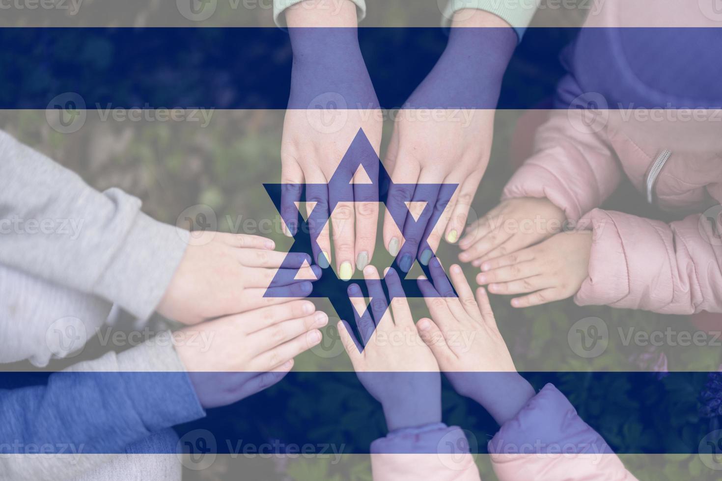 Hands of kids on background of Israel flag. Israeli patriotism and unity concept. photo