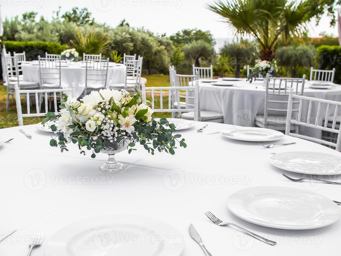 Table at luxury wedding reception event. Beautiful flowers on table and serving dishes and glasses and decoration photo