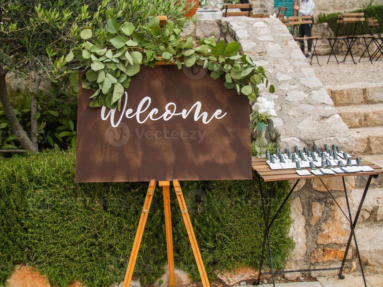 Plaque with inscription greeting guests at wedding. Welcome inscription sign wedding decorations. Wedding decor outdoor marriage photo