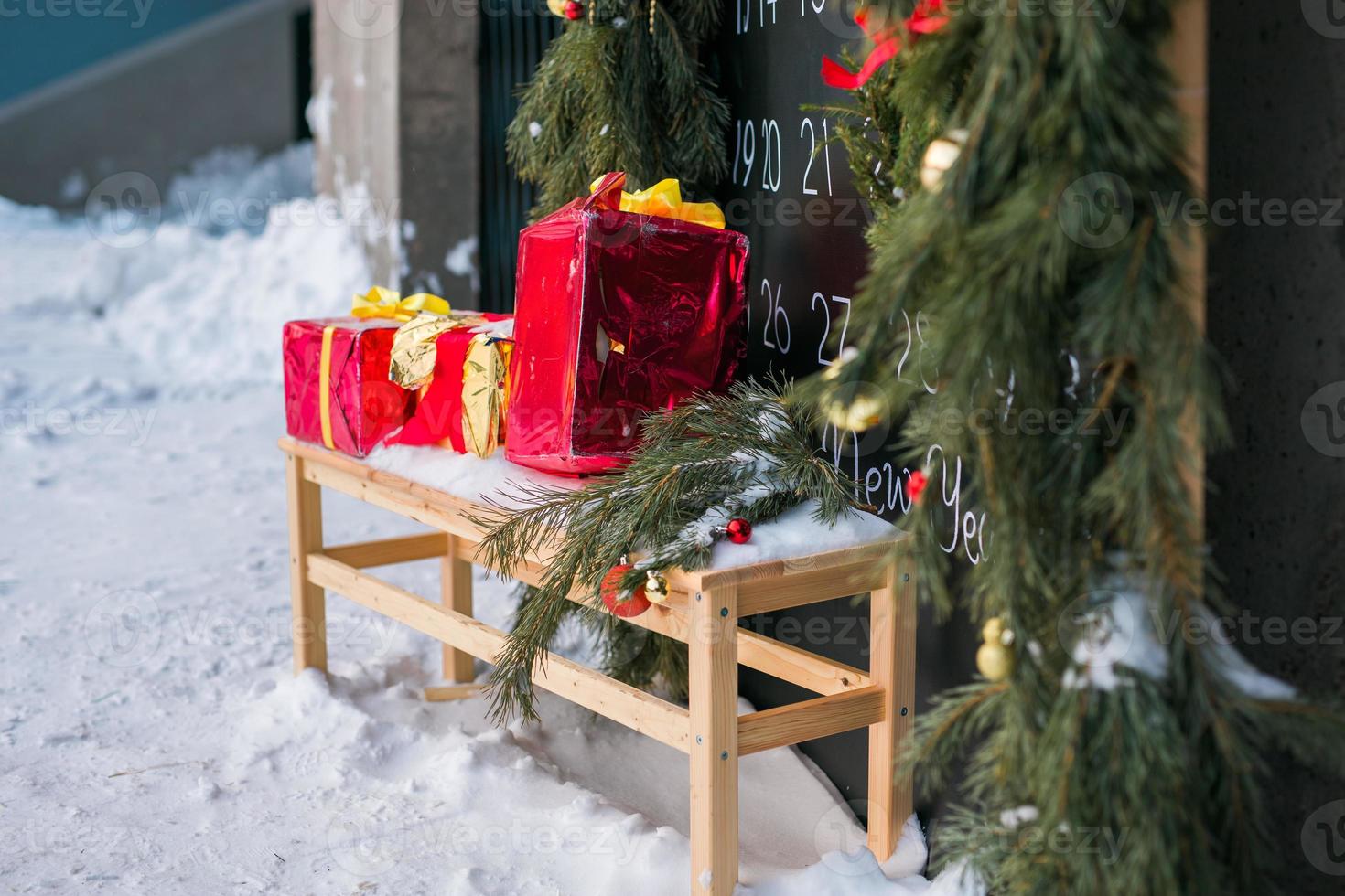 Handmade xmas gift boxes on bench on snow. Christmas holiday celebration concept photo