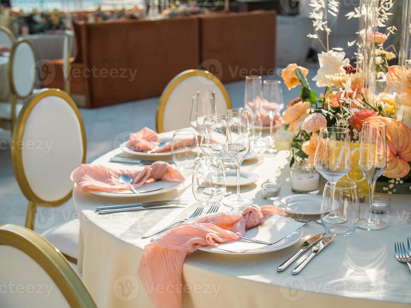 Table at luxury wedding reception event. Beautiful flowers on table and serving dishes and glasses and decoration photo