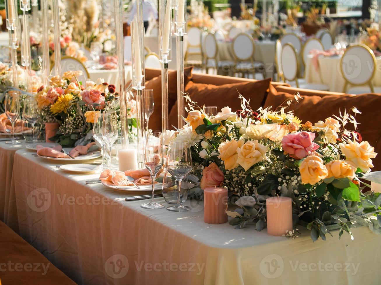 Wedding banquet concept. Chairs and round table for guests, served with cutler and, flowers and crockery and covered with a tablecloth photo