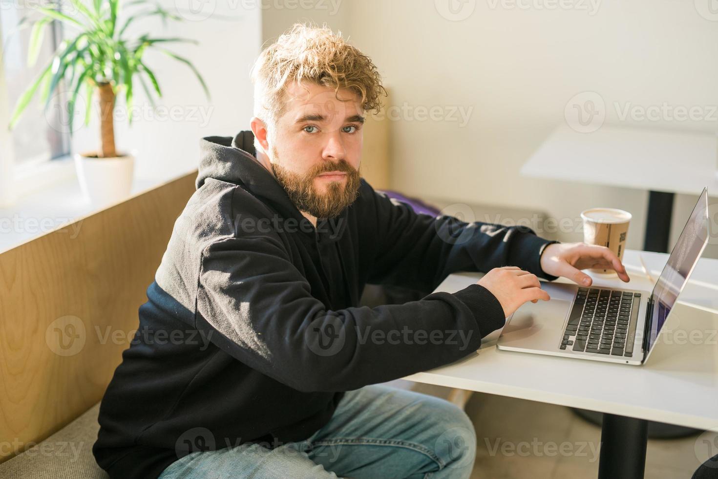 masculino chico descansando en café tienda chateando en social redes experto persona de libre dedicación disfrutando remoto trabajo mecanografía publicación para web Blog en ordenador portátil foto