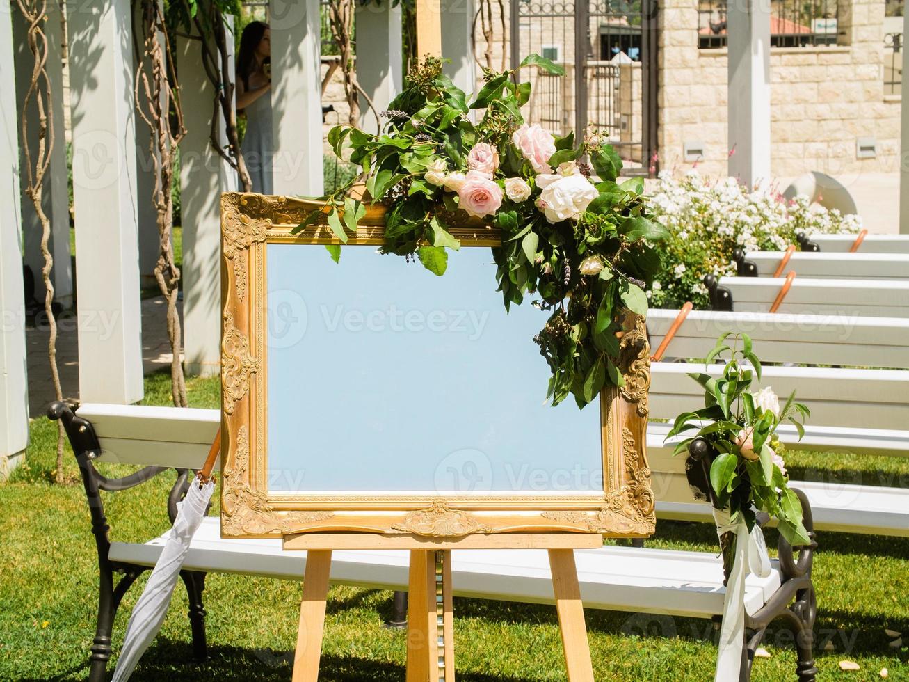 Wedding decorations. Plate with fresh flowers for of events inscription. Board for information and congratulations at ceremony and event photo