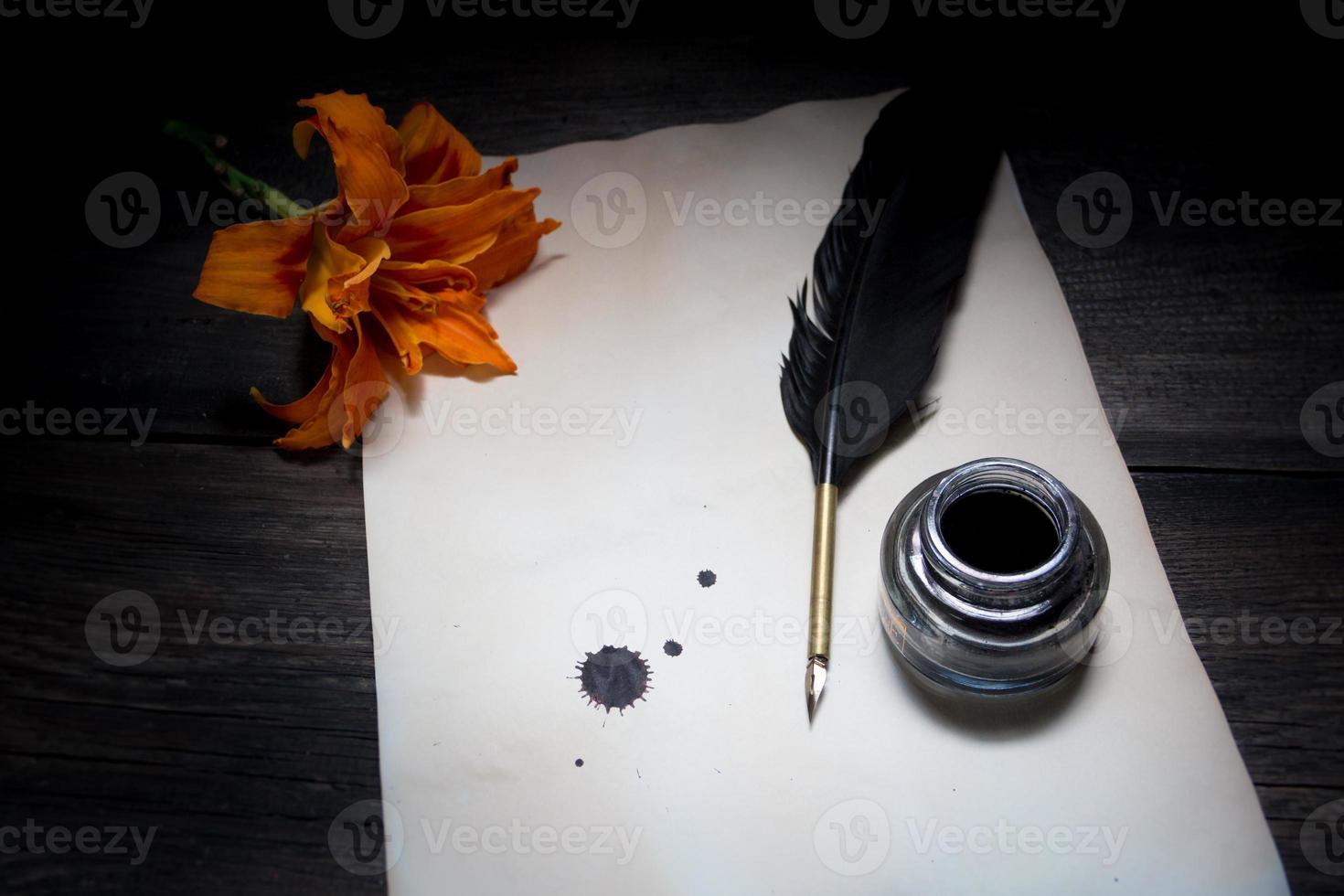 un sábana de antiguo papel con un bolígrafo y un flor foto