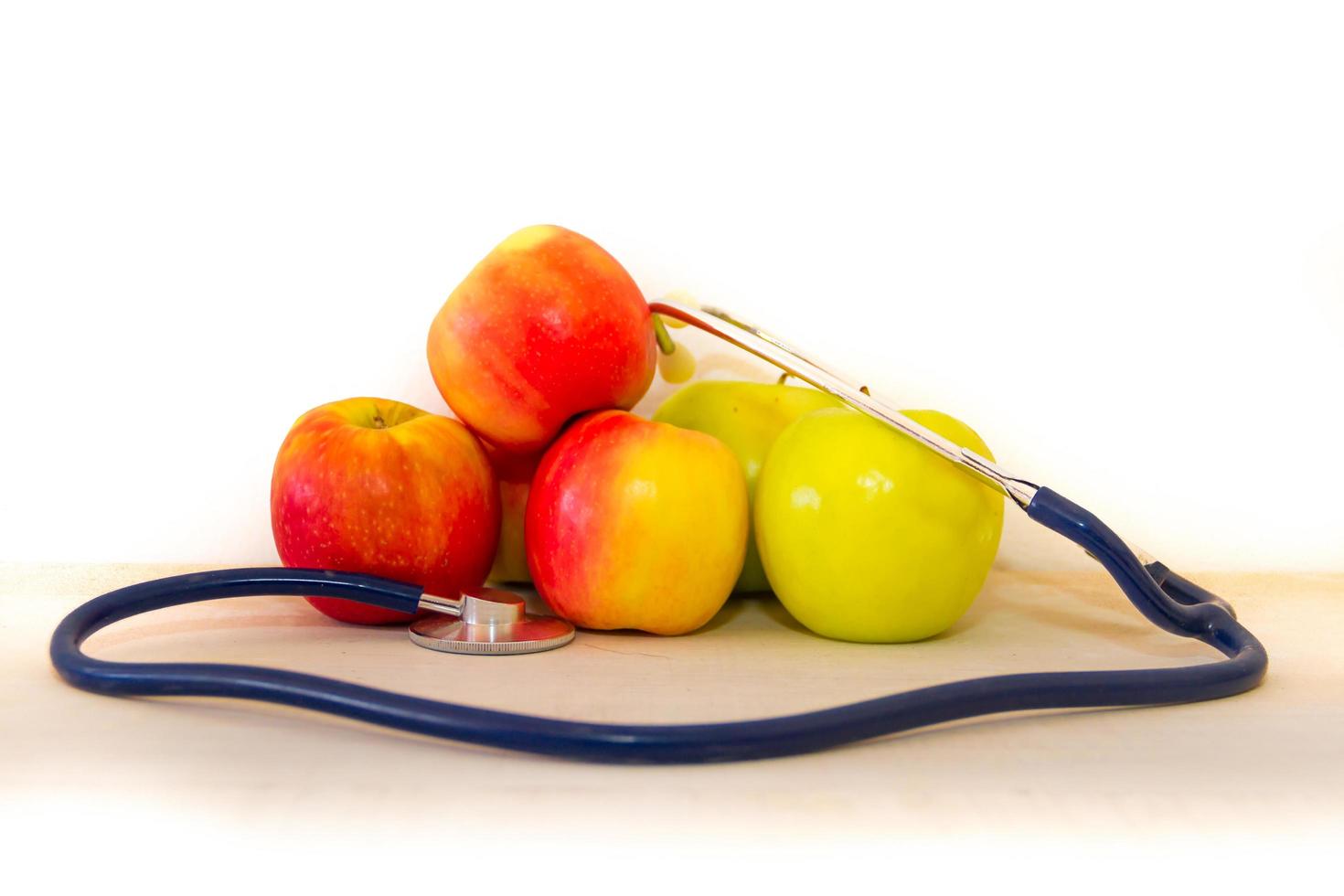 health concept with green and red apples and stethoscope photo